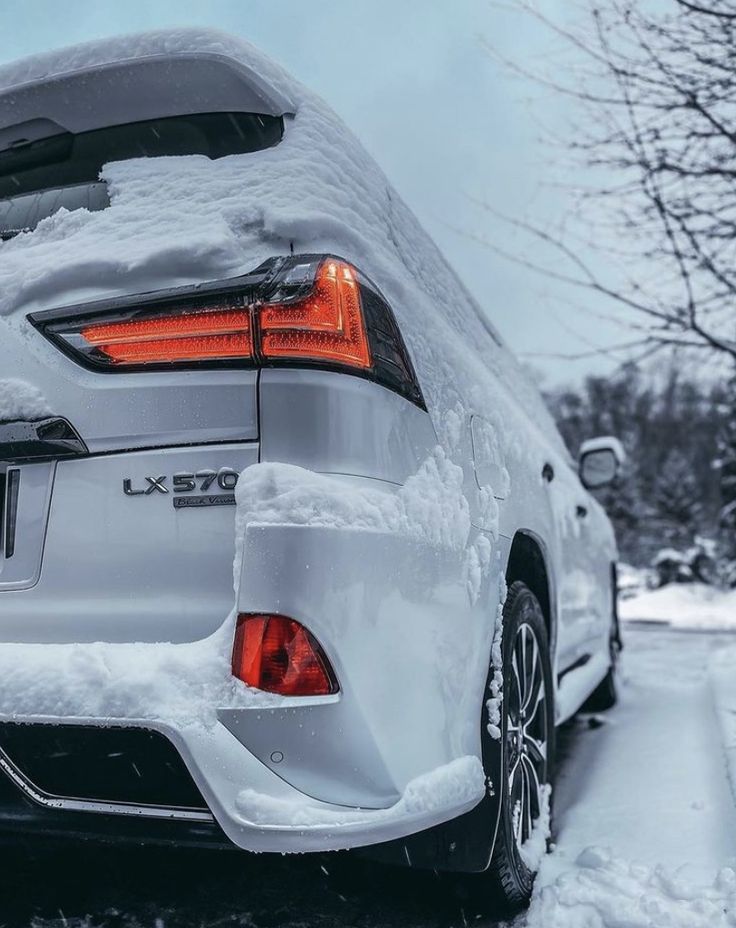 the back end of a white car covered in snow