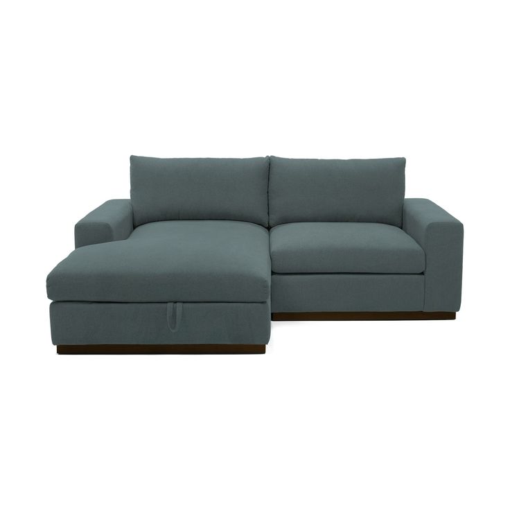 a blue sectional couch sitting on top of a white floor