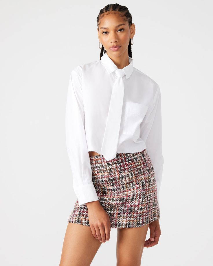 Expertly crafted from cotton poplin, the DOM top is a versatile and stylish addition to your wardrobe. Featuring a cropped button down design, it offers a functional pocket and adjustable tie for added convenience. Elevate your look and embrace the chic and functional style of this must-have top. Cropped button-down collared top Nonremovable tie with zipper to adjust height Raw hem Front functional pocket Length: 19" 100% cotton Hand wash Payton is 5ft 10in and is wearing a size small Vanessa is Elegant Cropped Cotton Shirt, Elegant Cotton Cropped Shirt For Work, Chic Button-up Cropped Workwear Shirt, Chic Button-up Cropped Shirt For Work, Spring Workwear Cropped Shirt, Chic White Cropped Shirt For Office, Chic White Cropped Shirt For Work, Office Cotton Cropped Tops, Classic Cropped Shirt For Office