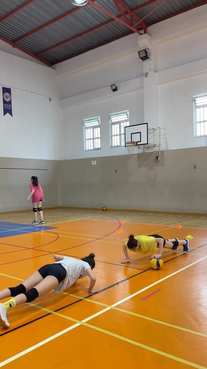 two girls are playing basketball on an indoor court