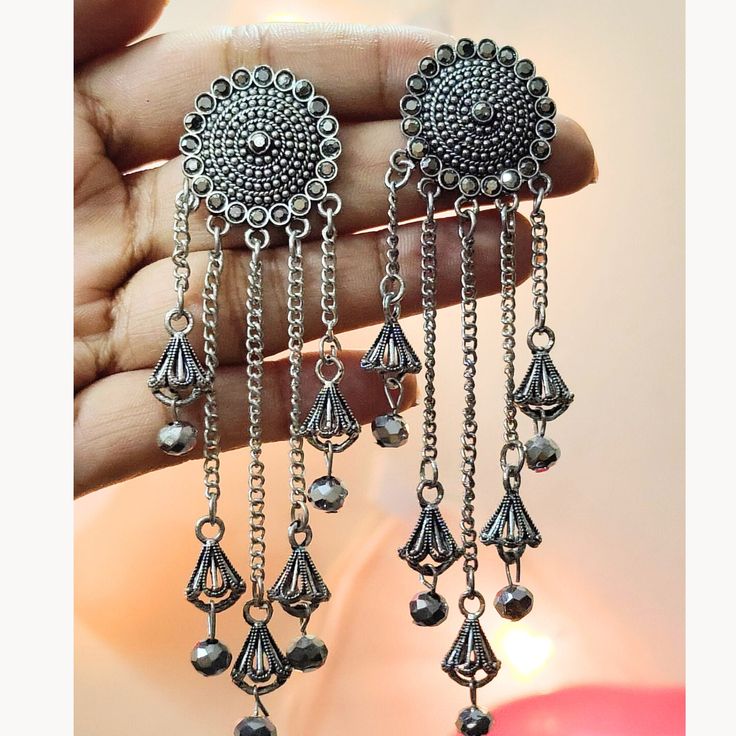 Overview: This Dangle and Drop Earrings set will leave you Amazed for sure. These have excellent finish and gives out an exquisite sense of style. this certainly is for special occasions such as Anniversary, Engagement, Party, Wedding or for gifting. Item Description: Material: German Silver suitable for all kinds of dressy occasions OCCASION: PARTY WEAR , WEDDING, MARRIAGES, CASUAL, DAILY WEAR Best Suited for Gifting Care Instructions: For the longevity of your ornaments: ▪Dos 1)Before keeping Silver Chandelier Earrings With Latkans For Gift, Silver Chandelier Earrings With Latkans As A Gift, Silver Metal Tassel Earrings For Wedding, Silver Chandelier Earrings With Dangling Beads For Festivals, Silver Dangle Earrings With Latkans, Silver Teardrop Chandelier Earrings With Latkans, Silver Long Drop Jewelry For Festivals, Elegant Dangle Jhumkas For Festivals, Bohemian Dangle Jhumkas