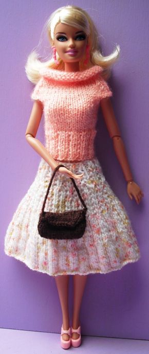 a barbie doll wearing a dress and holding a purse