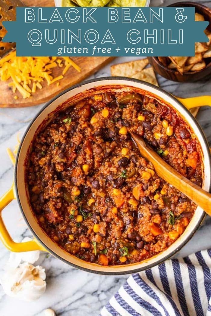 black bean and quinoa chili in a yellow pot with a wooden spoon on the side