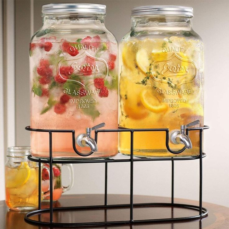 two mason jars filled with lemonade and raspberry punch on a wire rack