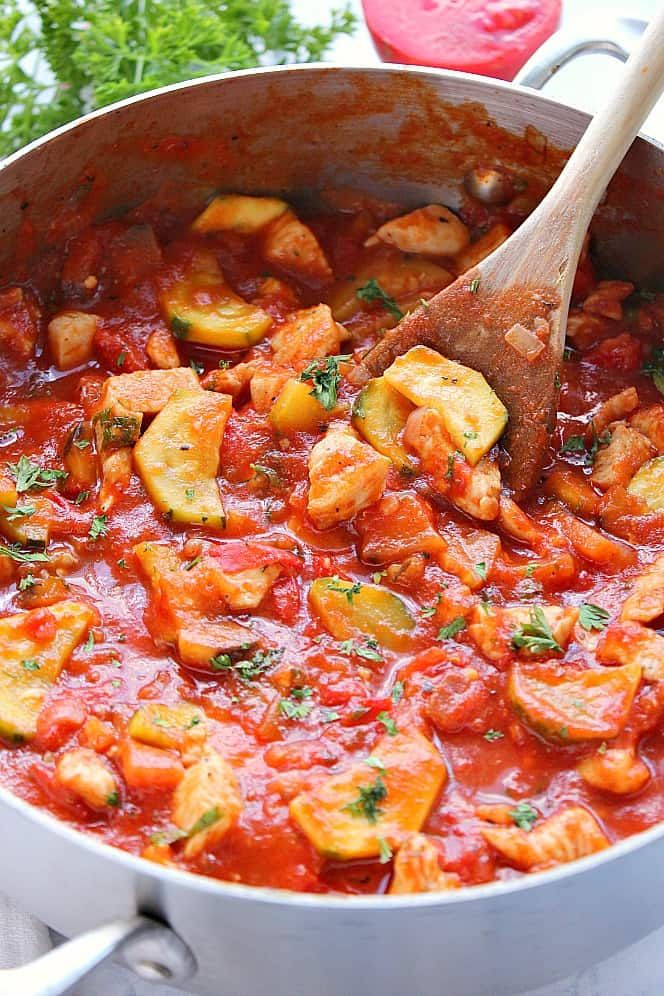 a large pot filled with food and a wooden spoon