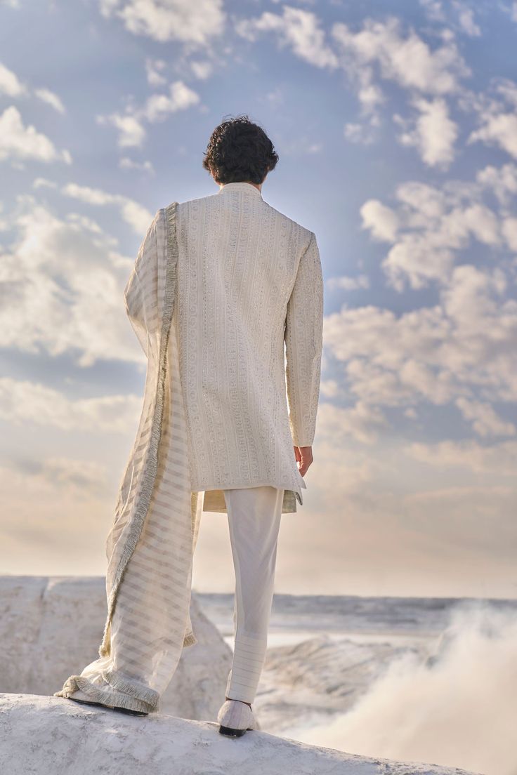 This sherwani set features all over intricate dori embroidery highlighted in delicate pearl and gold sequin. The ensemble is paired with an off-white cotton silk kurta and churidar.From Seema Gujral's Elements collection. DELIVERY TIMEPlease allow 6-8 weeks for your outfit to arrive. FABRIC DETAILSSherwani, Raw Silk Kurta, Cotton Silk Dupatta, Chanderi Silk Chudidar, Cotton Silk Professional cleaning only. Designer Raw Silk Bandhgala With Dupatta, Wedding Cotton Silk Sherwani With Naqshi, Unstitched Off White Bandhgala For Eid, Unstitched Off-white Bandhgala For Eid, Eid Raw Silk Bandhgala With Dupatta, Wedding Cotton Silk Sherwani With Dupatta, Eid Bandhgala With Dupatta In Raw Silk, Festive Cotton Silk Sherwani With Dupatta, Fitted Cotton Silk Sherwani With Dupatta