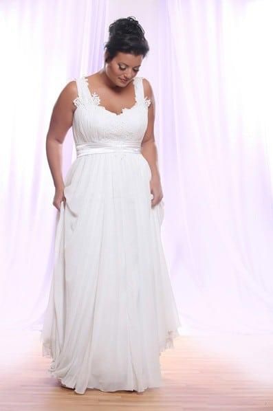 a woman in a white dress is posing for the camera with her hands on her hips