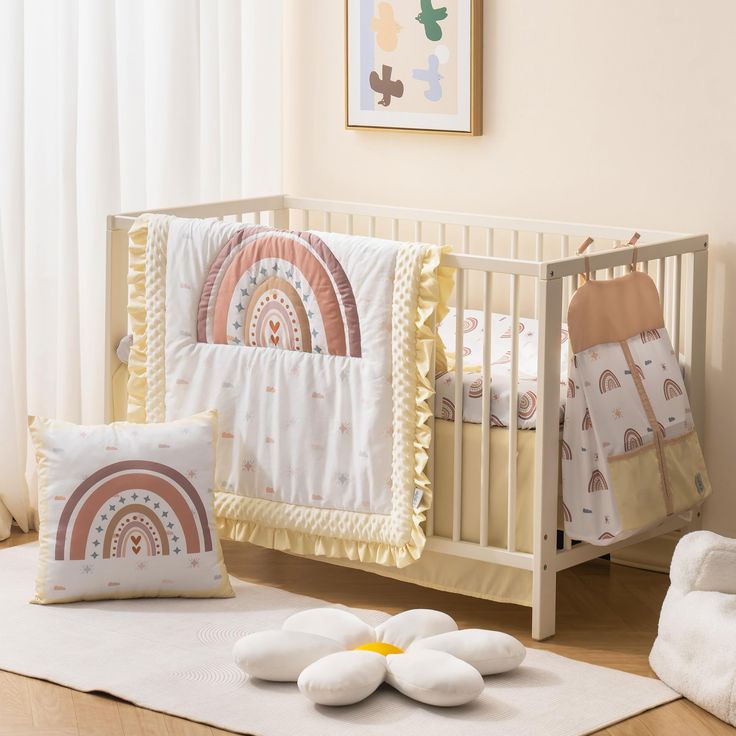 a baby crib with pillows and blankets on the floor