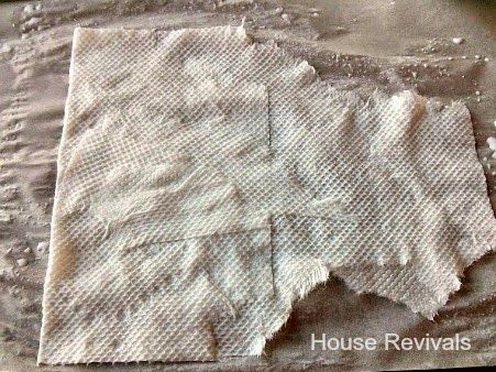 two pieces of cloth sitting on top of a metal pan covered in white paint and dirt