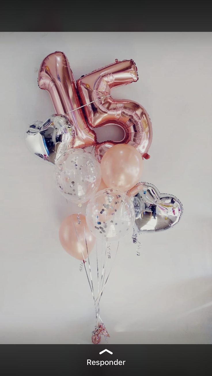 a bunch of balloons that are shaped like the number five on a white background with silver and pink foil