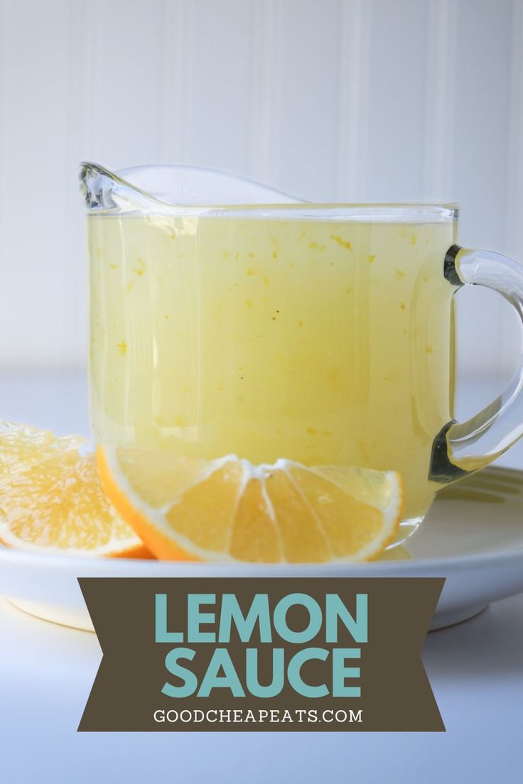 a glass mug filled with lemon sauce on top of a plate next to an orange slice