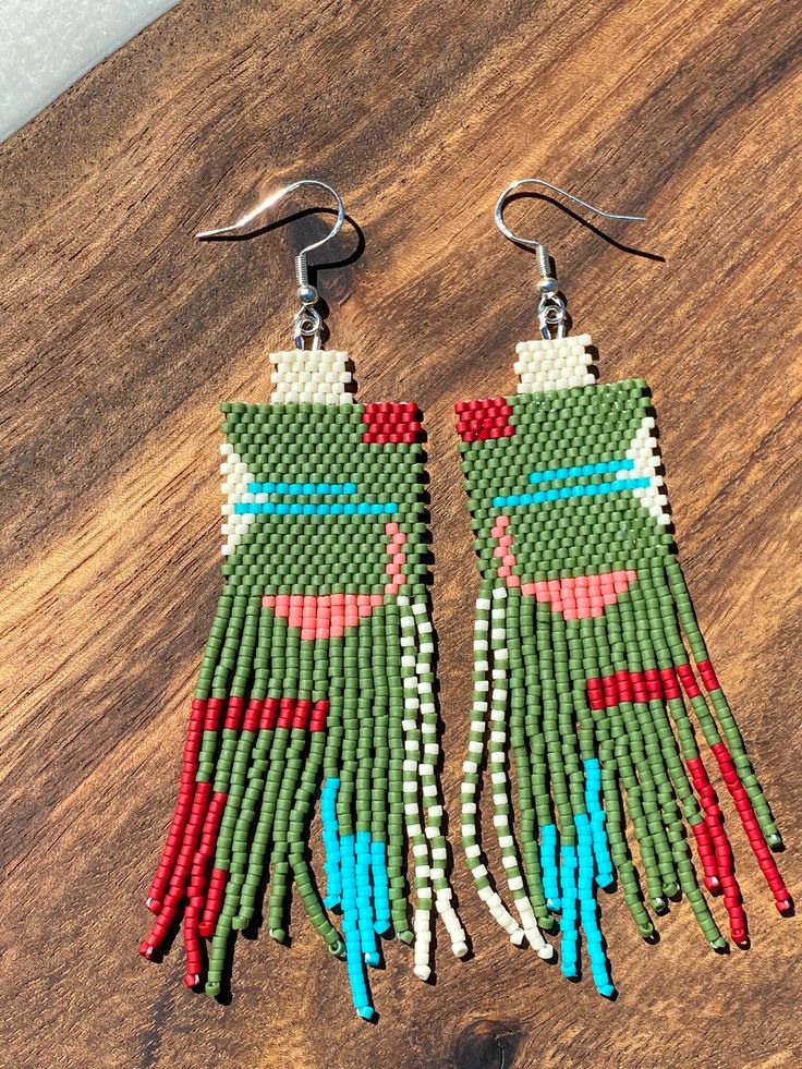 Two-toned Seed Beaded Earrings, hand created by me in small town Alaska! These earrings are made to order and have silver findings and components. The primary color is green! They're beautiful and lightweight statement earrings that are hand stitched. They're perfect for all sorts of gifts (Mother's Day, birthdays, Christmas, and graduation) or simply a new addition to your collection! They usually ship in 1-2 business days via USPS ** Please note: These earrings are individually handmade, so no two are exactly the same** Southwestern Green Dangle Earrings, Handmade Southwestern Green Earrings, Unique Green Festival Earrings, Unique Green Earrings For Festivals, Southwestern Green Beaded Dangle Earrings, Handmade Southwestern Green Beaded Earrings, Artisan Green Handwoven Beaded Earrings, Southwestern Style Handwoven Dangle Jewelry, Green Southwestern Beaded Earrings Gift