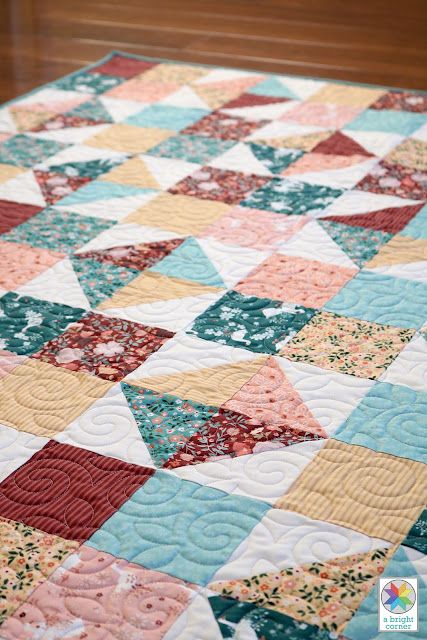 a quilt is laying on top of a wooden floor