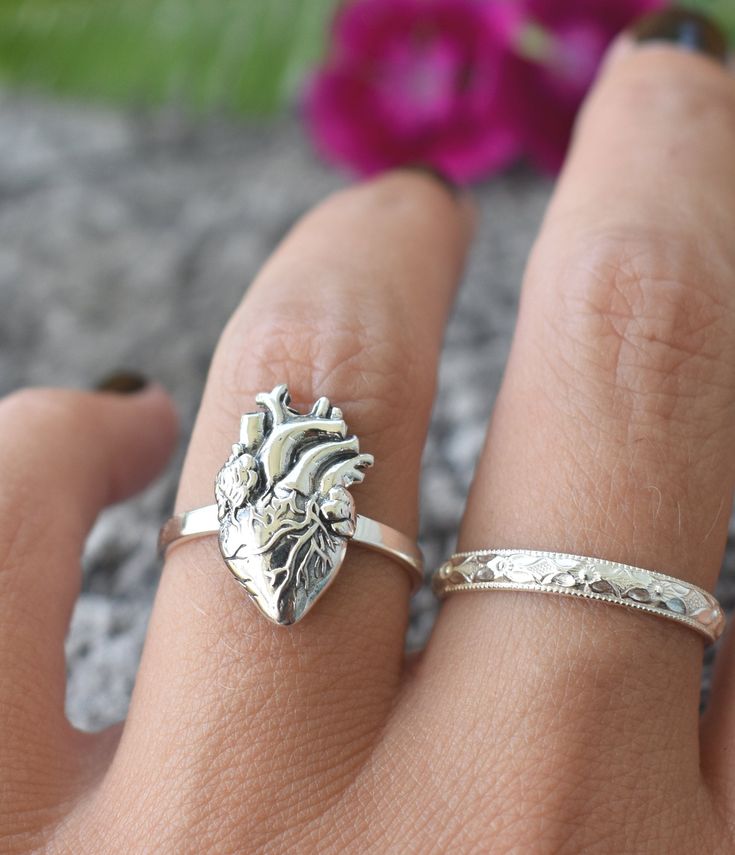 "Anatomical Heart Ring details: -Solid .925 sterling silver -Phases section measures 17mm x 10mm -Smooth ring band measures 2mm wide -Comfortable and easily stackable! -US Sizes 6-8 *Anatomical Heart Stacking Ring set shown here: https://www.etsy.com/listing/843409056/anatomical-heart-ring-sterling-silver?ref=shop_home_active_1&frs=1 Looking for a last minute or unique Christmas gift? Visit our \"READY TO SHIP\" section here, ships out in one business day https://www.etsy.com/shop/AWildViole Unique Adjustable Heart-shaped Ring, Unique Adjustable Heart Ring, Unique Adjustable Heart Shaped Ring, Silver Spiritual Heart Cut Jewelry, Hypoallergenic Heart Jewelry For Promise, Valentine's Day Hypoallergenic Heart Ring, Nickel Free Heart Shaped Anniversary Rings, Symbolic Heart Shaped White Gold Jewelry, Nickel-free Heart Ring For Anniversary