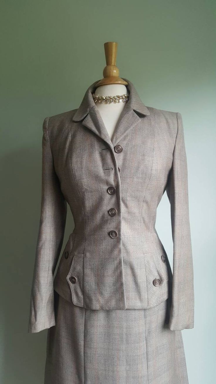 Impeccably tailored skirt suit by iconic '40s label Joselli features structured shoulders; princess seams; an elegant Glen plaid wool exterior in shades of tan with a subtle striking orange accent; a full crepe lining; and two jacket pockets accented by decorative double flaps. Side metal zip on skirt. Excellent condition. Label: Joselli Juniors Era: 1940s JACKET Bust up to 36/37 inches Waist up to 29/29.5 inches SKIRT Waist up to 27 inches Hips/seat up to 42/43 inches Length 30.5 inches ➸ visit Fitted Beige Tweed Jacket With Buttons, Vintage Fitted Skirt Suit With Notch Lapel, Fitted Beige Tweed Jacket For Tailoring, Classic Notch Lapel Skirt Suit With Buttons, Classic Skirt Suit With Notch Lapel, Fitted Beige Tweed Jacket With Button Closure, Fitted Brown Tweed Jacket For Office, Single-breasted Skirt Suit For Fall Tailoring, Vintage Skirt Suit For Semi-formal Fall Occasions