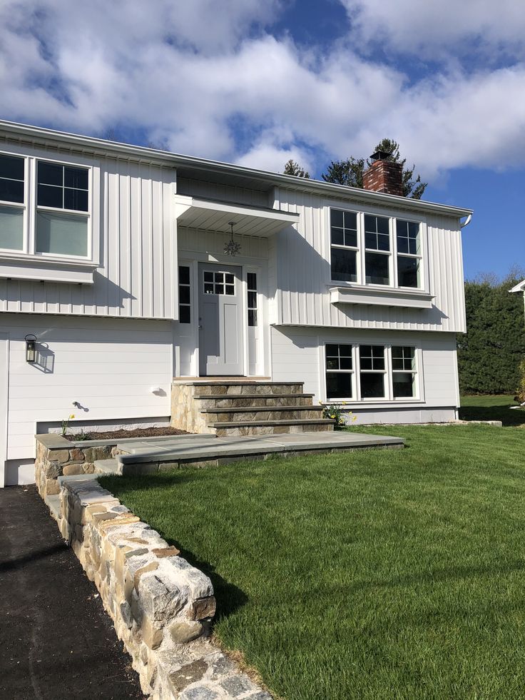 a white house with stone steps leading up to the front door