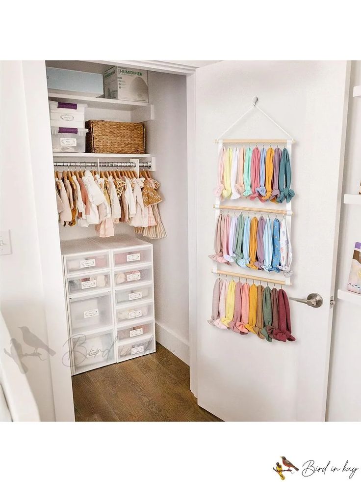 an organized closet with clothes hanging on the wall and storage bins in the door