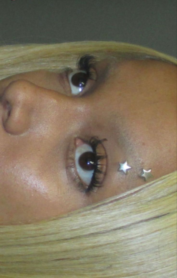 a woman with long blonde hair and stars on her eyes