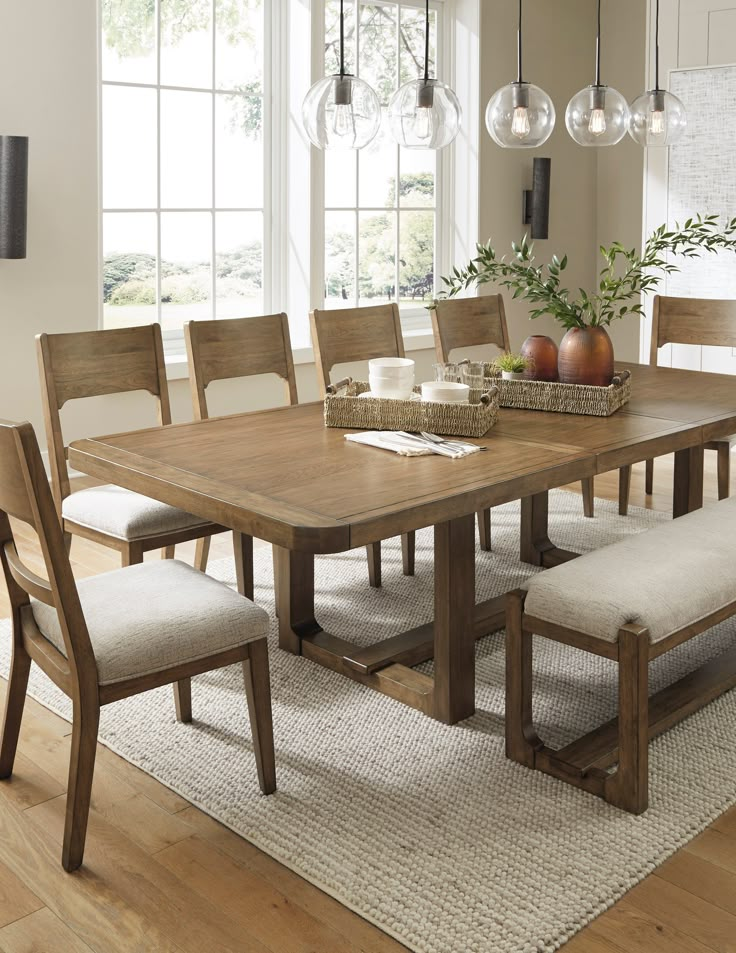 a dining room table with chairs and a bench