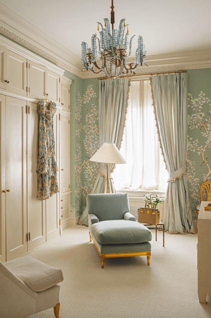 a living room filled with furniture and a chandelier hanging from the ceiling next to a window