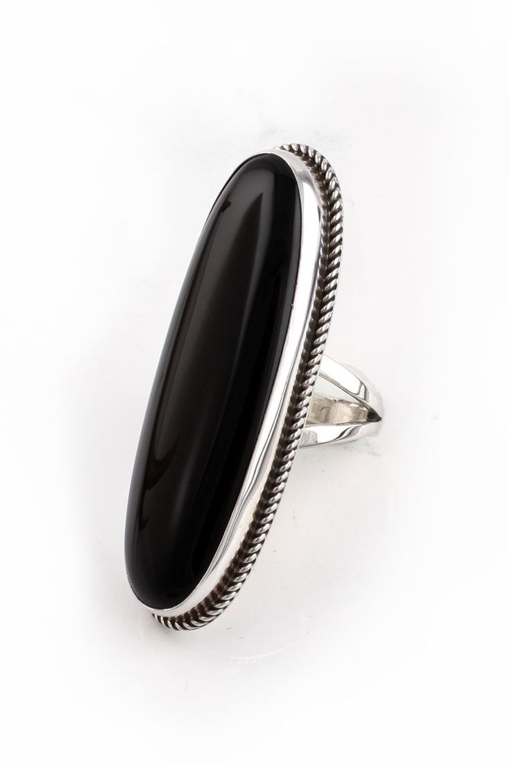 This Long Oval Black Onyx Ring (Size 6.75) is stunning. Famous Zuni artist, Viola Eriacho, created this dramatic sterling silver and black onyx ring that is sure to make a statement. A large long oval stone is bezel set in hand-stamped sterling silver and surrounded with a rope twist. Long oval shapes make fingers appear slender and provide a sophisticated style. Wear this distinctive ring with your little black dress and you’re set to go in style. Lightly oxidized and polished for a beautiful l American Rings, Native American Rings, Silver Eagle, Rope Twist, American Indian Jewelry, Silver Eagles, Black Onyx Ring, Onyx Ring, Oval Stone