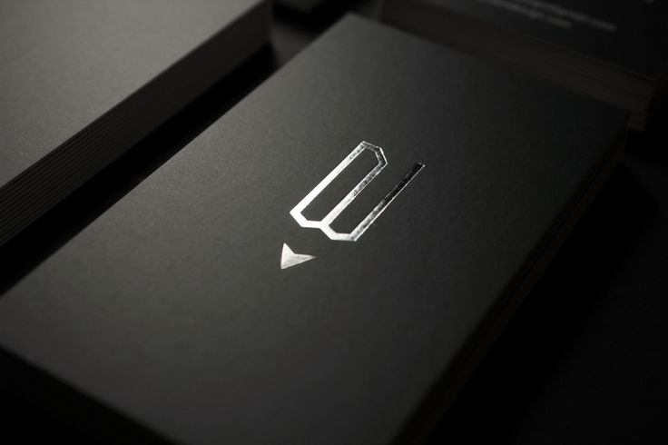 the business card is black and white with silver foil on it's side, which has an arrow in the middle