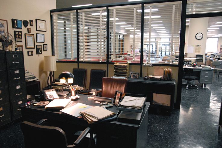 an office filled with lots of clutter and papers on top of a desk next to a window