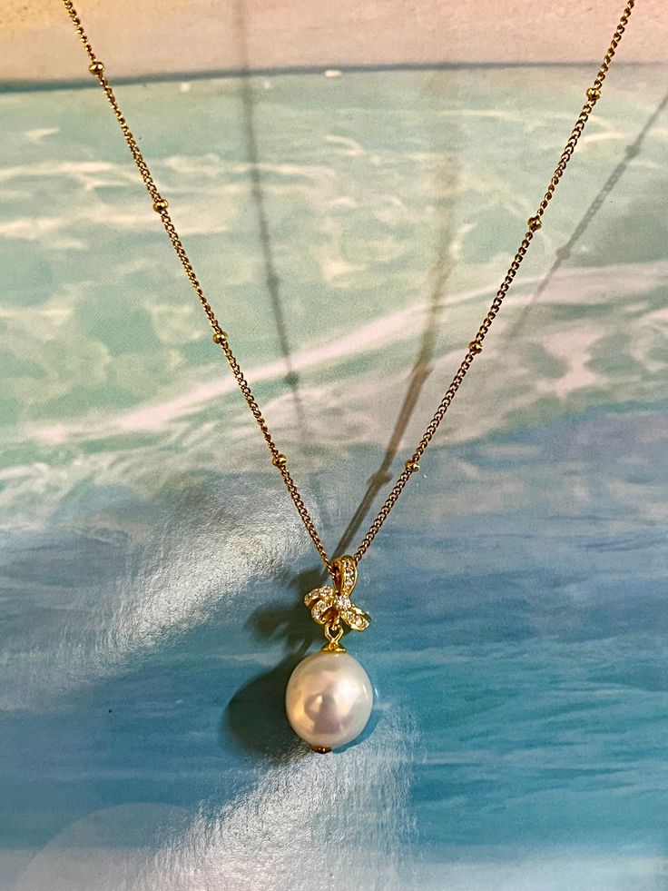 This exquisite necklace features a lustrous baroque freshwater pearl, cultivated for its unique irregular shape and captivating texture, ensuring that each piece is truly one-of-a-kind. Sitting atop the pearl is a floral adornment crafted from S925 silver, embellished with sparkling zirconia stones that add a touch of glamour. The pendant is suspended on a durable stainless steel chain, which complements the pendant's sheen and offers lasting shine. The design embodies a luxurious yet refined aesthetic, perfect for elevating any formal ensemble. Luxury Drop Pearl Pendant Necklace, Elegant Baroque Pearl Teardrop Pendant Jewelry, Pearl Necklace With Flower Pendant And Pearl Charm, Exquisite Pearl Pendant Necklace, Elegant Baroque Pearl Round Pendant Necklace, Elegant Teardrop Pearl Chain Necklace, Exquisite Pearl Necklace With Pearl Pendant, Elegant Flower Pendant Necklace With Pearl Chain, Luxury Pear-shaped Pearl Drop Necklace