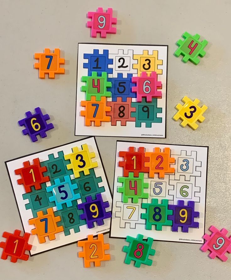 four different colored puzzles laid out on a table with numbers in the middle and one missing