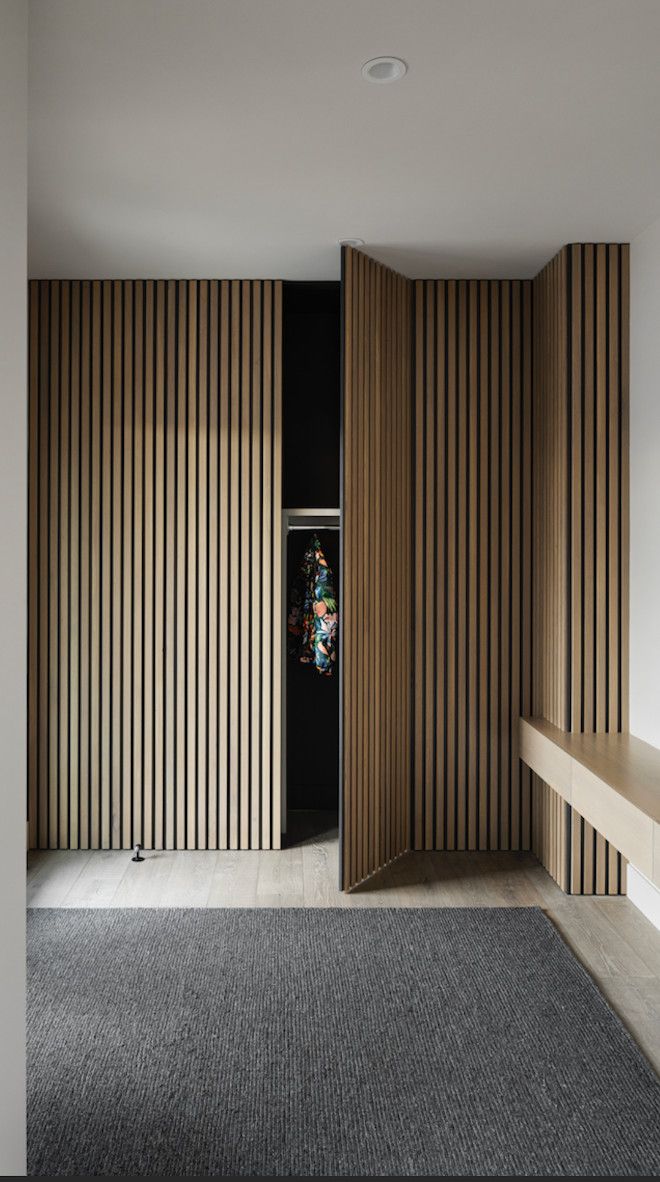 an open door in a room with wooden slats on the walls and carpeted floor