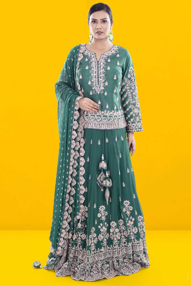 Embody sophistication and elegance with our Party Wear Lehenga D-262. Adorned with stunning sequence and thread work, this piece exudes luxury and exclusivity. The long top adds a touch of grace to this already breathtaking ensemble. Make a statement at any event with this exquisite lehenga. Elegant Palazzo Set With Cutdana On Chinon, Green Embellished Palazzo Set For Wedding, Embellished Green Palazzo Set For Wedding, Floor-length Georgette Palazzo Set For Transitional Seasons, Transitional Floor-length Georgette Palazzo Set, Long Sleeve Chinon Sharara With Cutdana, Silk Palazzo Set With Zari Work For Reception, Embellished Green Palazzo Set For Reception, Green Chinon Palazzo Set For Reception