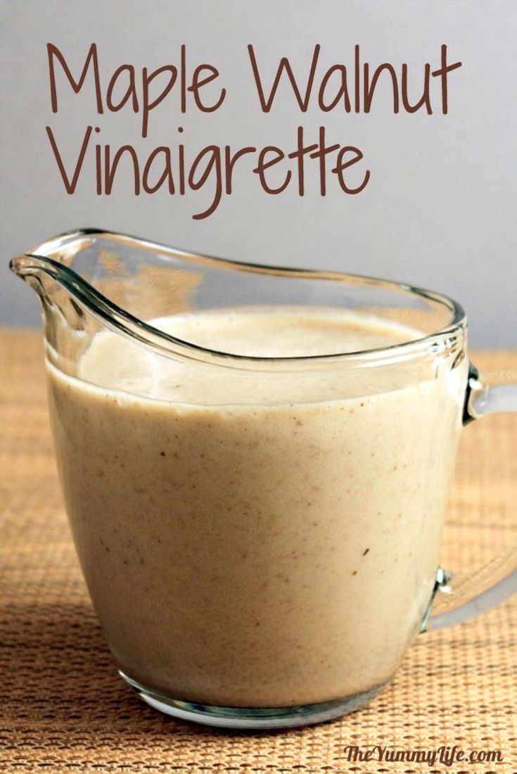 a glass pitcher filled with maple walnut vinaigrette on top of a table