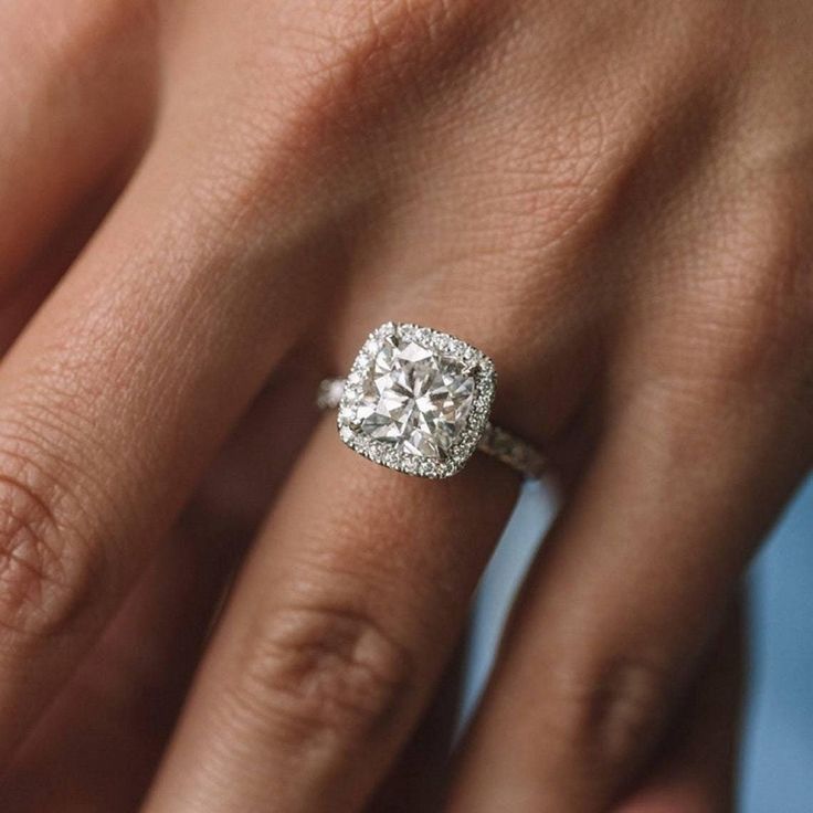 a woman's hand with a diamond ring on her finger and an engagement band