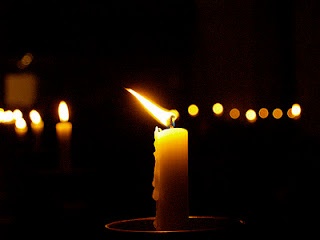 a candle that is lit in the dark with candles behind it and text reading princess diana she was like a candle in the wind