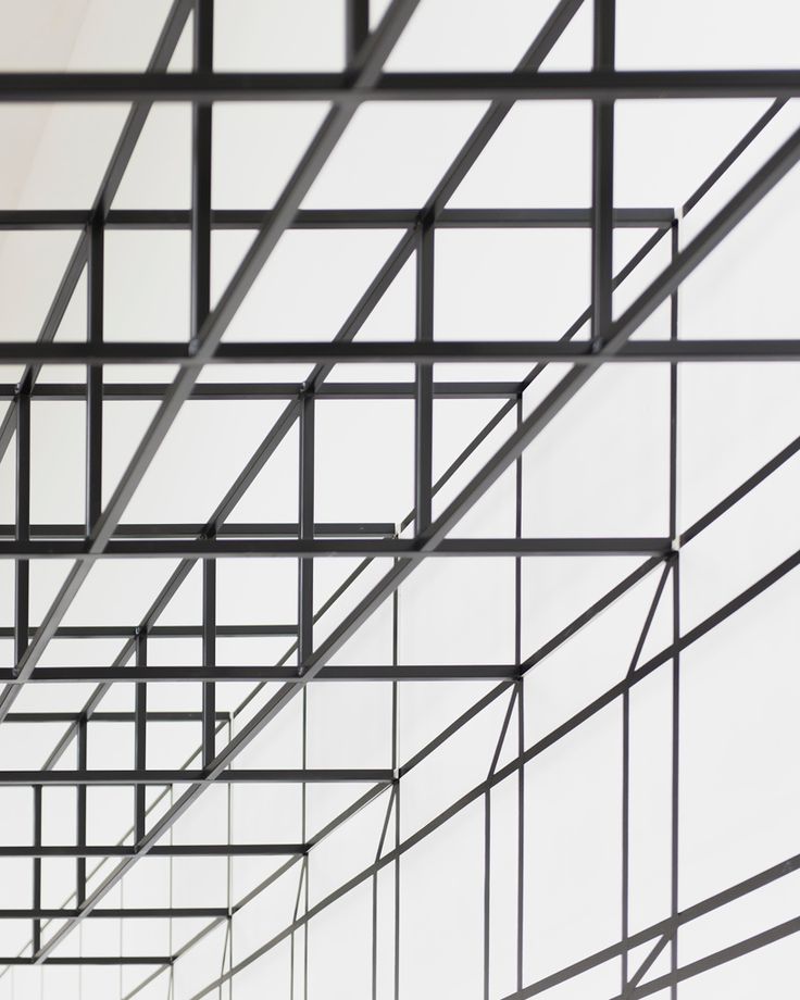 the ceiling is made up of black metal bars and grids that are connected to each other