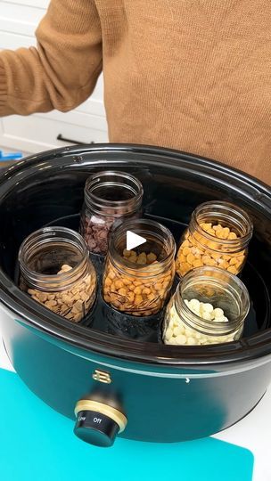 a man holding a large crock pot filled with different types of food in it