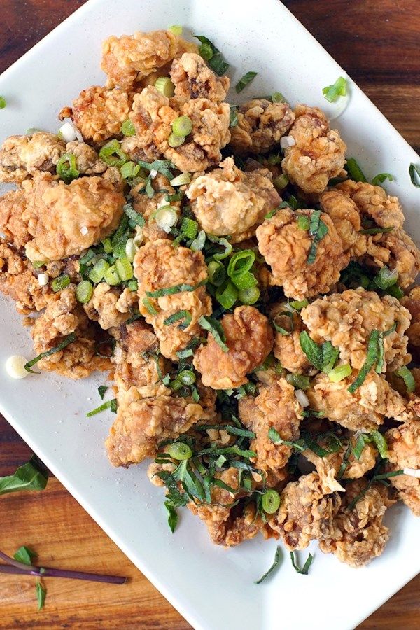 a white plate topped with fried food on top of a wooden table