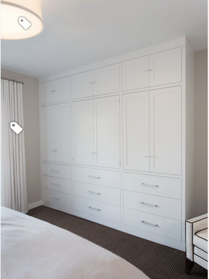 a bedroom with white cabinets and carpeted flooring