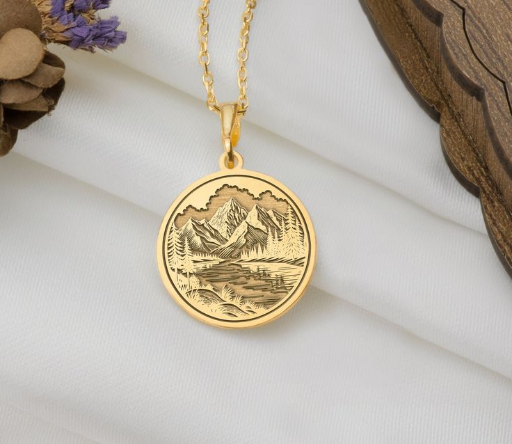 Reconnect with the serene beauty of nature with our Mountain River Pendant Necklace. This exquisite piece features a detailed design of majestic mountains and a flowing river, capturing the tranquil essence of the great outdoors. Mountains symbolize strength and endurance, while rivers represent the flow of life and renewal. This necklace combines these elements to celebrate the harmony and splendor of nature, making it a perfect accessory for those who cherish the natural world and seek to carry a piece of it with them. Wear this necklace to carry the beauty of nature with you, and let it remind you of the peaceful and invigorating essence of the great outdoors. * Materials: 14K Solid Gold, 925 Sterling Silver, 14K Gold Plated, 14K Rose Plated * Pendant Thickness: 0.8mm for 14K Solid Gold Flowing River, Gold River, Mountain River, Majestic Mountains, Detailed Design, Nature Jewelry, Halloween Shopping, Silver Pendant, Charm Necklace