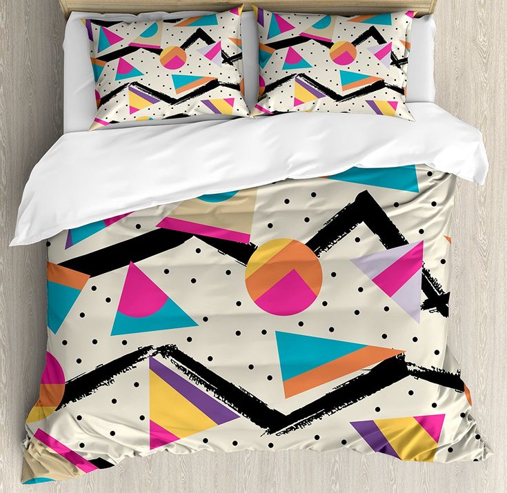 a bed with two pillows on top of it next to a wooden headboard and wall