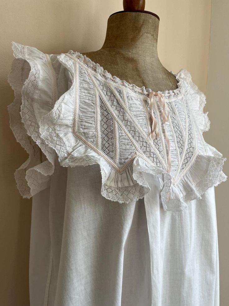 A very pretty and feminine original Edwardian nightgown.  We are selling the matching bloomers separately in our Etsy shop: https://jessicamonroestore.etsy.com/listing/1795539230 Made from snowy white cotton. Very full skirt.  Decorated with ample lace, palest pink embroidery and pintucks. A beautiful soft corded ribbon has been threaded through. It appears to be the original.  There are no fastenings.  Freshly and carefully laundered.  Highly wearable. Measurements are taken when laid flat: Und Edwardian Nightgown, Nightgown Pattern, Pink Embroidery, Rose Pale, Dress Slip, Women's Nightgowns, Embroidery Lace, Gown Dress, Nightgowns