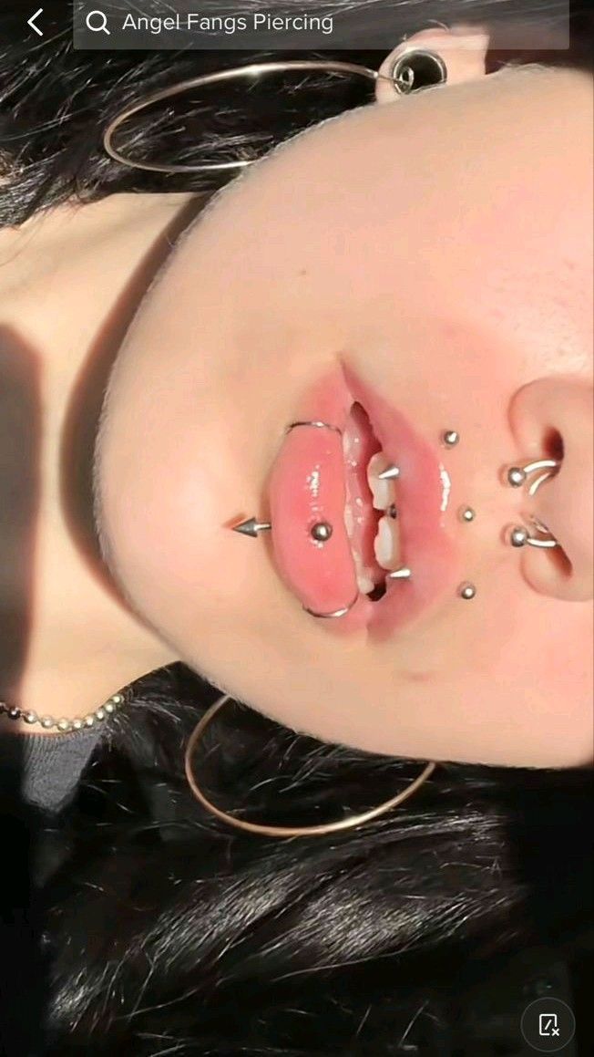 a close up of a person with piercings on their face