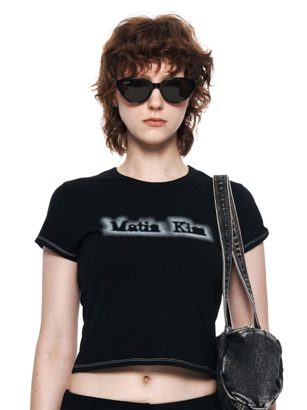 This is a trendy and casual t-shirt by MATIN KIM that is made out of high quality and sturdy fabric. With unique design detail and trendy mood, you can style it for your casual and young daily outfit.- Cotton blend fabric with high elasticity- Casual logo detail- Slim cropped silhouette Modern Fitted T-shirt With Graphic Print, Black Edgy T-shirt For Spring, Trendy Black Cotton T-shirt, Black Trendy T-shirt With Logo Print, Trendy Black T-shirt With Logo Print, Edgy Cotton Tops With Text Print, Edgy Fitted Text Print T-shirt, Urban Fitted T-shirt With Letter Print, Urban Fitted T-shirt For Spring