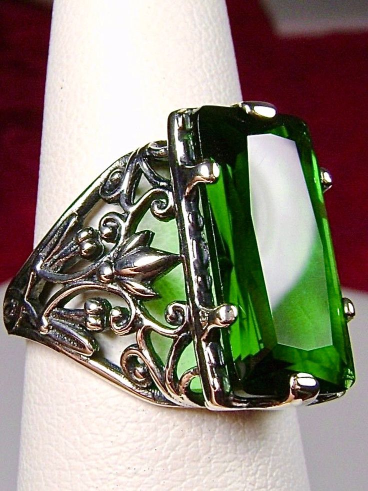 Green Emerald Ring Baguette Design#32 Introducing the Baguette D32, a stunning piece of wearable art that pays homage to the opulent Victorian era. Crafted with meticulous attention to detail, this exquisite filigree Antique reproduction in sterling silver is sure to captivate anyone with a love for vintage-inspired jewelry. At its center, lies a flawless 7ct green emerald gemstone, radiating a dazzling hue that catches the light with every movement. The baguette rectangle-cut gemstone measures Antique Emerald Jewelry For Formal Occasions, Elegant Green Intaglio Ring, Classic Emerald Jewelry For Evening, Classic Evening Emerald Jewelry, Elegant Rectangular Jewelry For Evening, Victorian Green Jewelry For Party, Formal Emerald Ring With Rectangular Shape, Elegant Engraved Emerald Jewelry, Formal Rectangular Emerald Ring