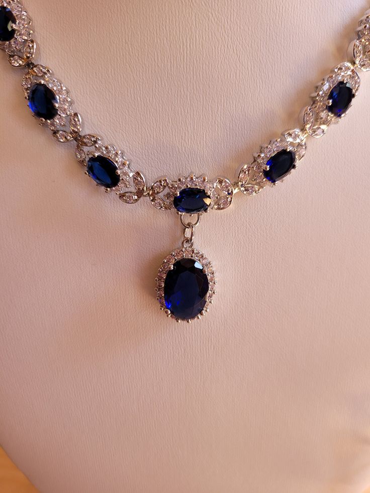 Created sapphire and diamond necklace and earring set.  Sapphire chain is 18 inches non adjustable and comes with a one inch extender.  Sapphires are 3mm oval and center stone is 7mm oval.  Diamond accents.  Earrings are two inches with a 1.75 inch drop.  7mm oval center stone.  Set in stamped 925 silver. Ruby And Sapphire Jewelry, Blue Sapphire Necklace Gold, Exquisite Oval Jewelry For Evening, Oval Jewelry With 17 Jewels For Evening, Formal Oval Necklace With 17 Jewels, Formal Oval Necklaces With 17 Jewels, Elegant Sapphire Necklace With Hand-set Details, Oval Diamond Necklaces For Party, Fine Jewelry Oval Evening Jewelry