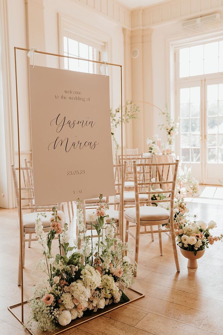 a sign that is sitting in the middle of a room filled with chairs and flowers