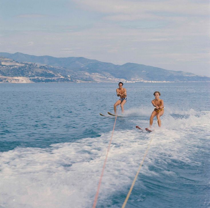 two people on water skis being pulled by a boat