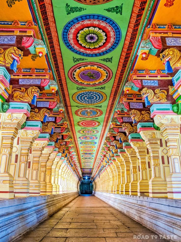 an ornate ceiling in the middle of a building with many columns and arches on each side