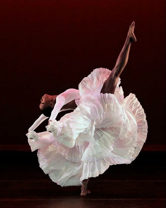 a woman in a white dress is dancing