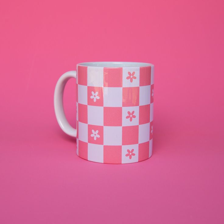 a pink and white checkered coffee mug on a pink background